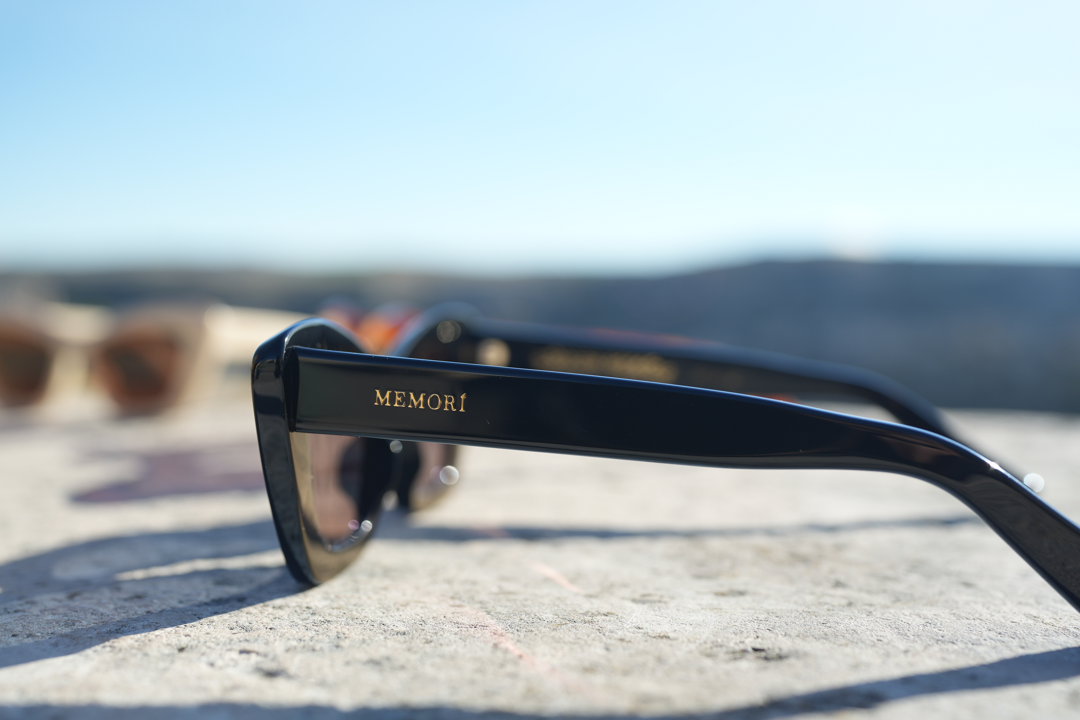 Memorí Italian cat eye sunglasses for small faces, close up image showing the Memorí logo in hold on the external temple arm.