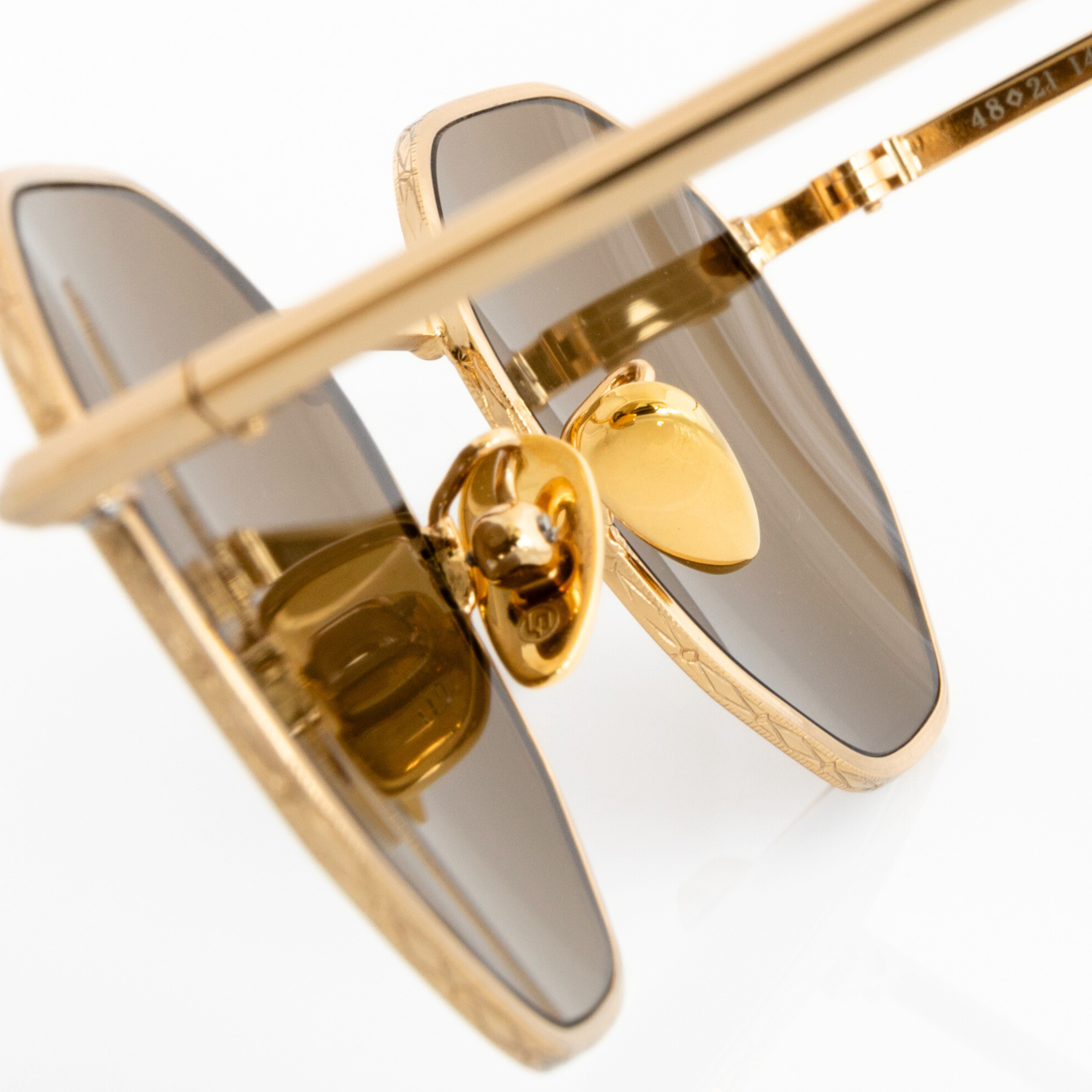 close-up view of gold metallic ceramic nose pads on Memorí small fit hexagon sunglasses. The nose pads are adjustable to fit different nose shapes and sizes.  