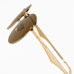 Gold frame Memorí sunglasses with warm brown lenses, zoomed in side view. The best sunglasses for small faces,  this photos showcases the edgy linear temple arm design. V shaped nose bridge, gold ceramic nose pads, and the Memorí logo in the upper corner of the lens are visible.