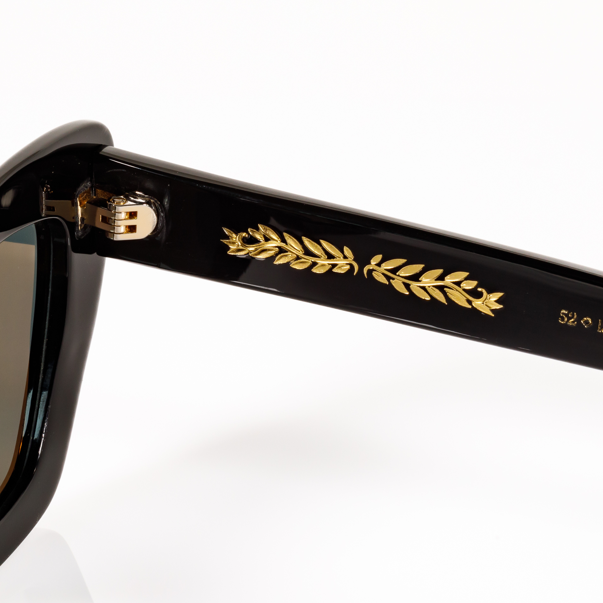 Gold laurel leaf hot stamping detail on the internal temple of Memorí black acetate cat eye sunglasses, the best cat eye sunglasses for small faces and petite faces