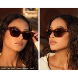 Tortoise pattern cellulose acetate sunglasses pictured on model with narrow face. Sunglasses fit her perfectly and are displayed from two angles. Lenses are dark brown, the model's eyes are not visible through the lenses in the photo.