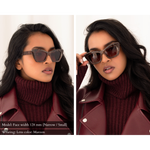 side by side photo of the same model wearing a maroon leather coat layered on top of a maroon sweater, and memori maroon marbled cat eye sunglasses. left photo shows the side view, right photo shows the forward-looking view where we can see the elegant cat eye shape of the lenses. Text on the photo reads: "Model: face width 128mm (Narrow/small) wearing lens color: Maroon".