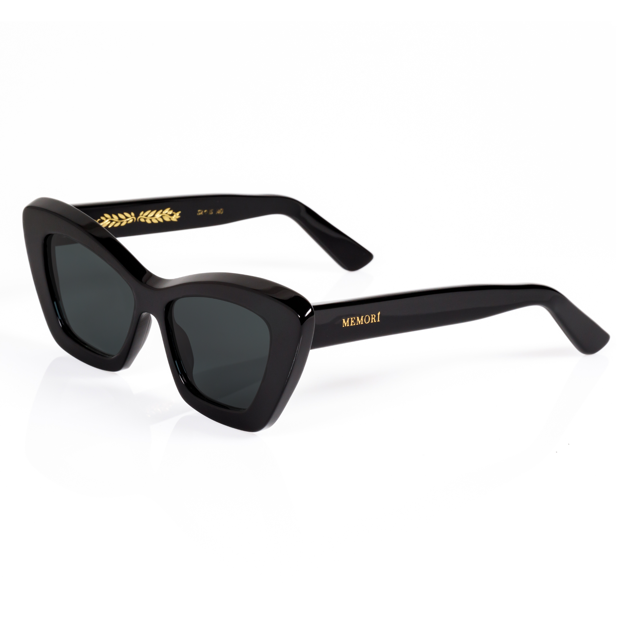 3/4 view of Memori black cat eye sunglasses. The design is sleek and elegant. This view shows of the top beveled edge, and the gold laurel dealing inside the temple arm. Memori logo in gold also appears as a small metal badge set into the acetate on the external temple arm.
