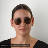 Model with 128mm width face (which falls into Narrow/Regular category) wearing the gold round Memorí sunglasses with brown lenses. 
