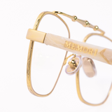 Close up macro view of the balaustra aviator glasses by Memori. Around the gold rim is a geometric pattern, with the "memori" logo inlaid into the acetate temple arm. 