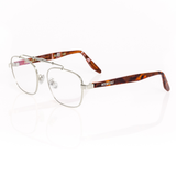 3/4 view of memori balaustra aviator optical frames in silver with transparent lenses, brown tortoise acetate temple arms, and a sculptural silver horizontal top bar on a white background. 