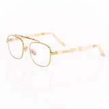 Balaustra aviator optical frames viewed from he corner. gold metal frame with marbled ivory and light brown acetate temple arms.  "Memori" logo in gold is visible inlaid into the acetate arm. Nose pads are gold with silicone cover. 