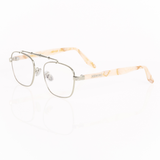 Balaustra aviator optical frames viewed from he corner. Silver frame with marbled ivory and light brown acetate temple arms.  "memori" logo in silver is visible inlaid into the acetate arm. Nose pads are silver with silicone cover. 