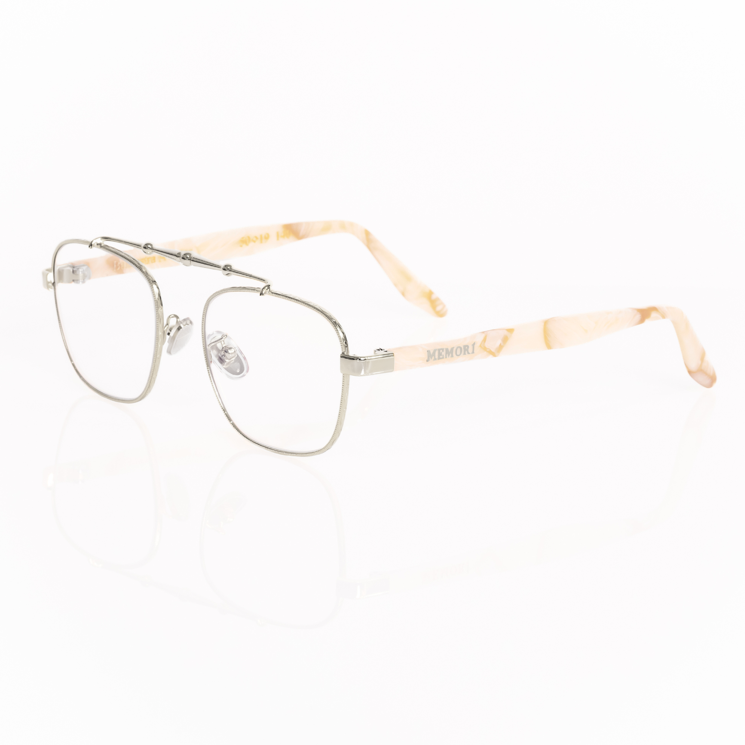 Balaustra aviator optical frames viewed from he corner. Silver frame with marbled ivory and light brown acetate temple arms.  "memori" logo in silver is visible inlaid into the acetate arm. Nose pads are silver with silicone cover. 