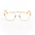 Front view of Memori Balaustra Aviator glasses on a white background. transparent lenses, gold frame, and ivory and light brown marbled acetate temple arms. Top bar has sculptural gold design details. 