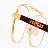 Close up of the geometric metal details around the rim of Memori Balaustra Aviator frames. "memori" logo is show inlaid on the acetate temple arm. 