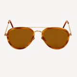 Forward view of aviator silhouette sunglasses on a white background. Lenses are a yellow/gold color, frame is gold, and there are acetate sheaths surrounding the lenses and at the temple tips in a brown color.