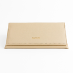 Photo of Memorí hardshell leather sunglass case. Case has an elegant, triangular design and is made of a textured, cream colored leather. Memori logo is embossed in small gold foil letters on the front of the flap. This eyewear case is very protective and would be suitable to protect luxury sunglasses in a suitcase or other environment subject to pressure. 