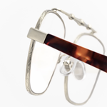 Detailed zoomed in photo of the geometric details that surround the rim of Memori balaustra Aviator glasses. 