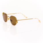 Gold metal sunglasses with brown lenses on a white background. 3/4 view shows chunky gold hoop piercings through the lenses. Pierced sunglasses. Ivory Marbled acetate temple tips. 