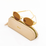 gold, oval framed sunglasses with intricate leaf details propped up on a leather zip sunglass pouch, which ships with purchase. 
